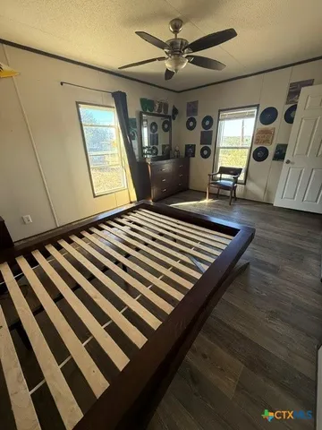 a bedroom with a bed wooden floor and window