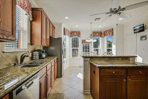 a kitchen with stainless steel appliances granite countertop a sink stove and refrigerator