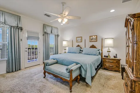 a spacious bedroom with a bed a chandelier and a mirror