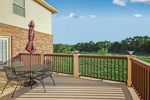 a view of a balcony with wooden floor and iron fence