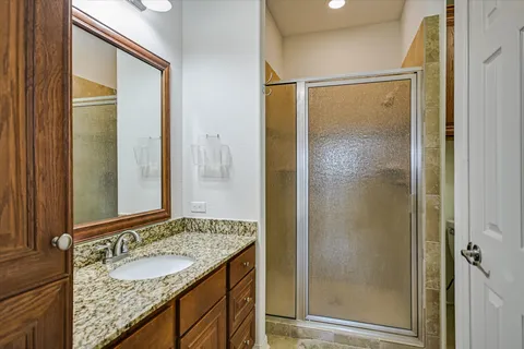 a bathroom with a granite countertop sink and a mirror