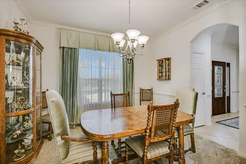 a view of a dining room with furniture and chandelier