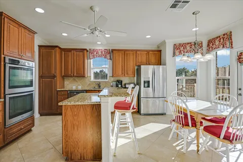 a kitchen with stainless steel appliances kitchen island granite countertop a refrigerator and a stove top oven