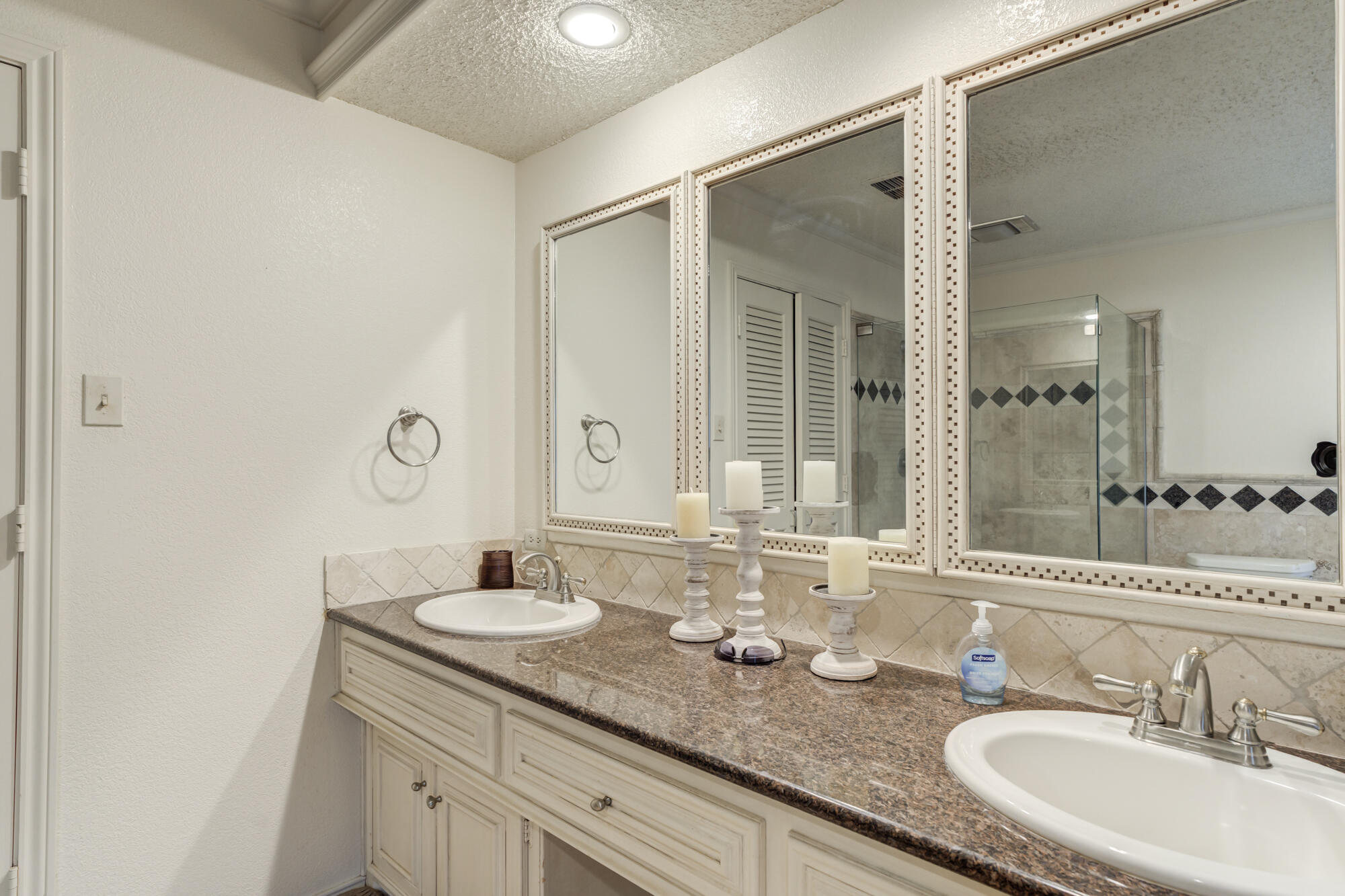 4405 89th Street Lubbock, TX 79424 - Photo 50 of 71 a bathroom with a granite countertop sink a large mirror and a shower