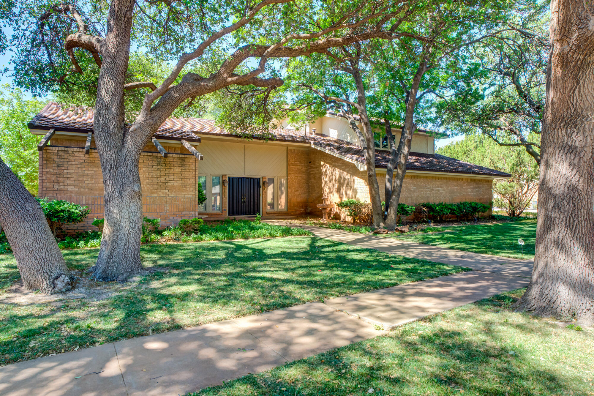 4405 89th Street Lubbock, TX 79424 - Photo 9 of 71 a backyard of a house with plants and large tree