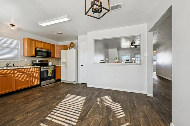 a kitchen with stainless steel appliances granite countertop a refrigerator and a stove top oven