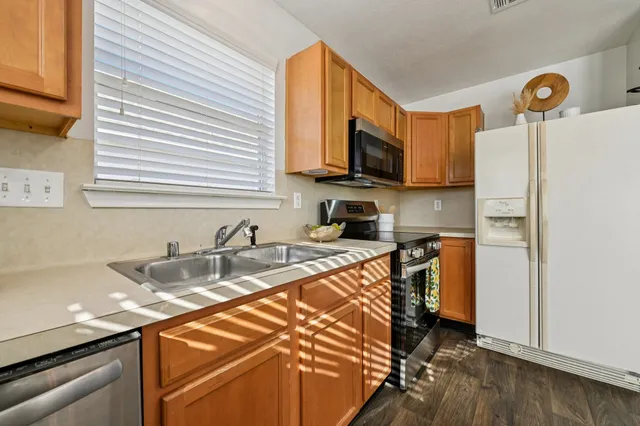 a kitchen with stainless steel appliances granite countertop a sink refrigerator and microwave