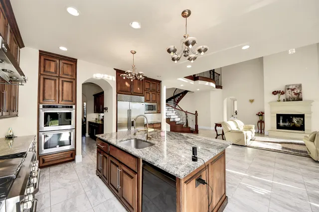 a kitchen with stainless steel appliances granite countertop a kitchen island a stove and a sink