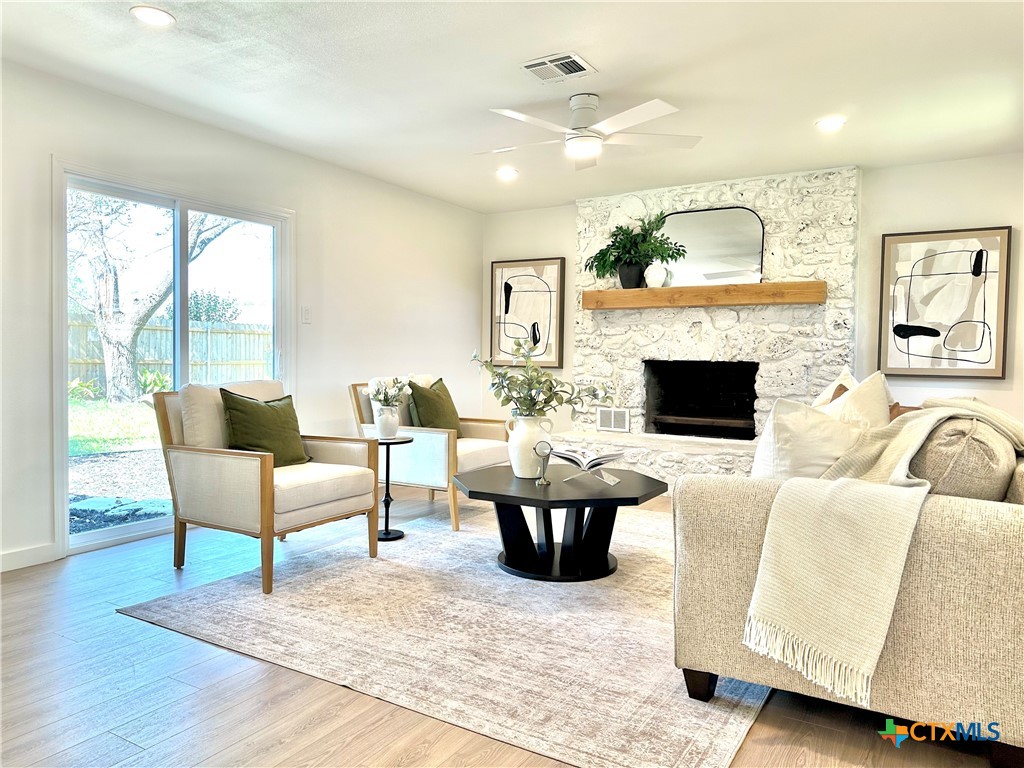 4412 Briar Cliff Road Temple, TX 76502 - Photo 13 of 28 a living room with furniture a fireplace and a floor to ceiling window