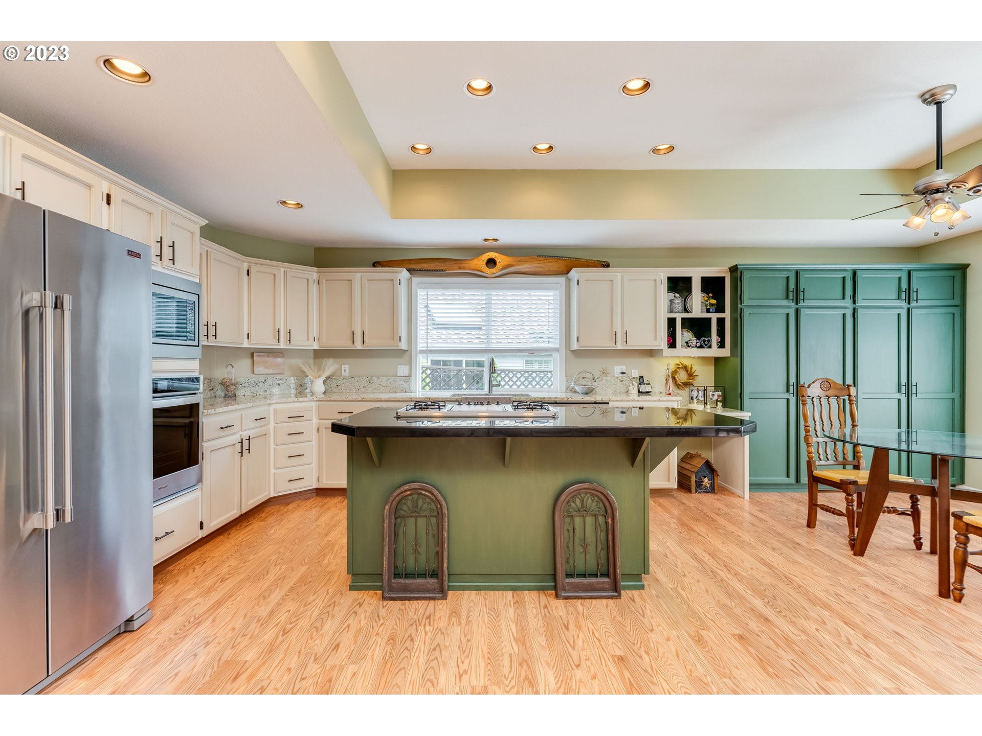 14029 Southeast 35th Loop Vancouver, WA 98683 - Photo 11 of 48 a kitchen with stainless steel appliances granite countertop a refrigerator a sink dishwasher a stove and a dining table with wooden floor