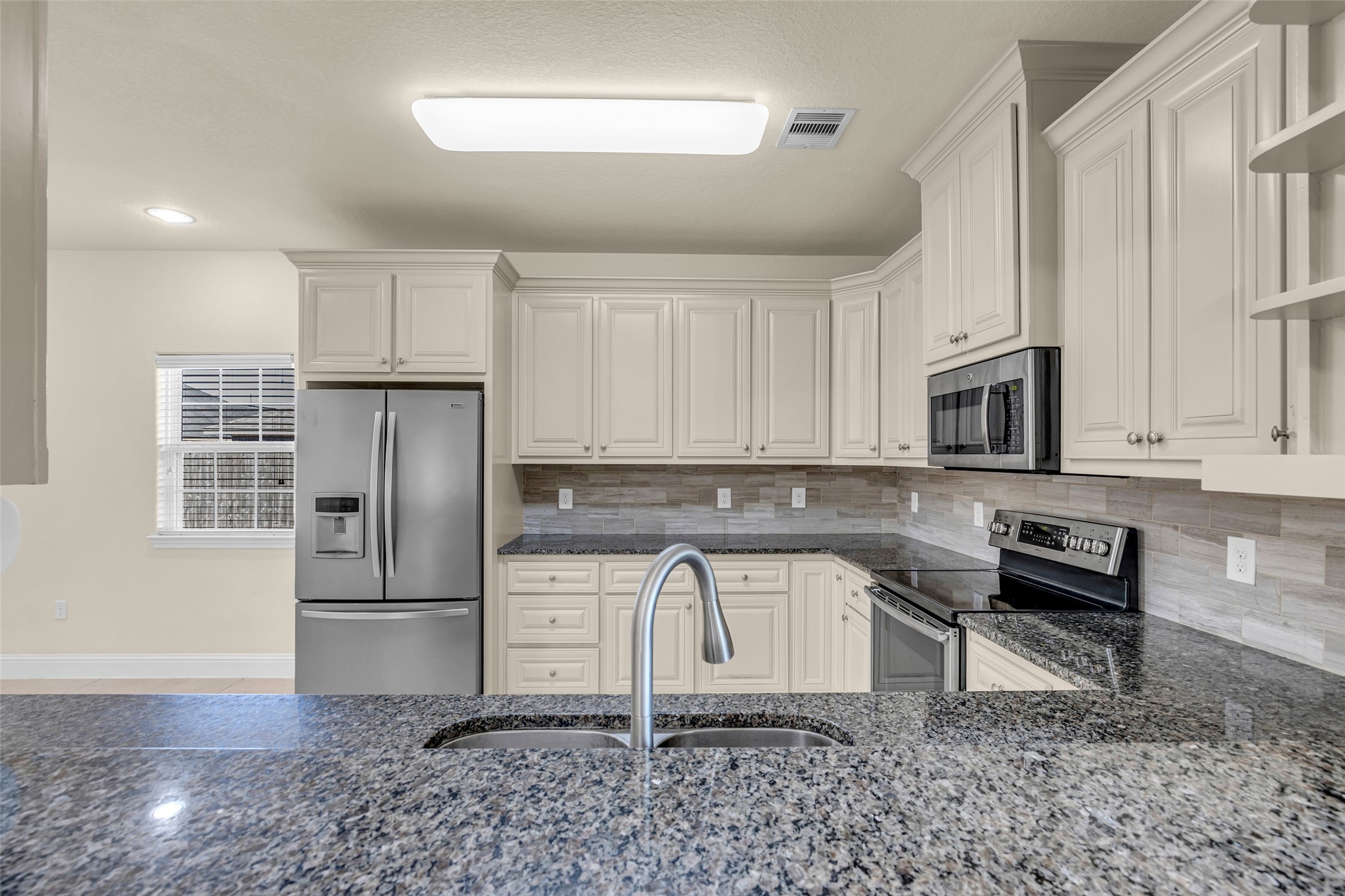 323 Texas Avenue Arcola, TX 77583 - Photo 11 of 27 a kitchen with stainless steel appliances granite countertop a refrigerator sink and stove