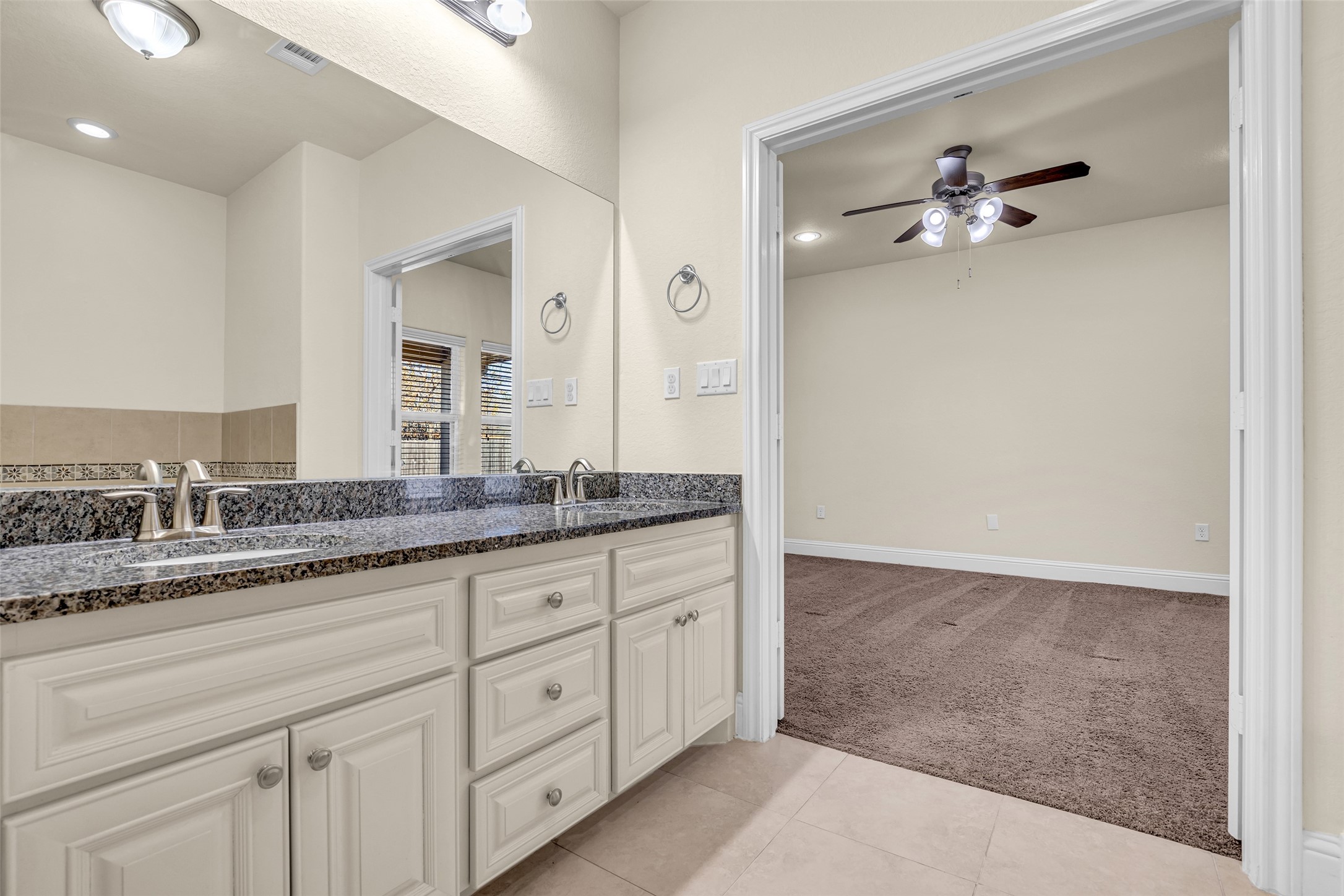 323 Texas Avenue Arcola, TX 77583 - Photo 19 of 27 a bathroom with a granite countertop sink and a mirror