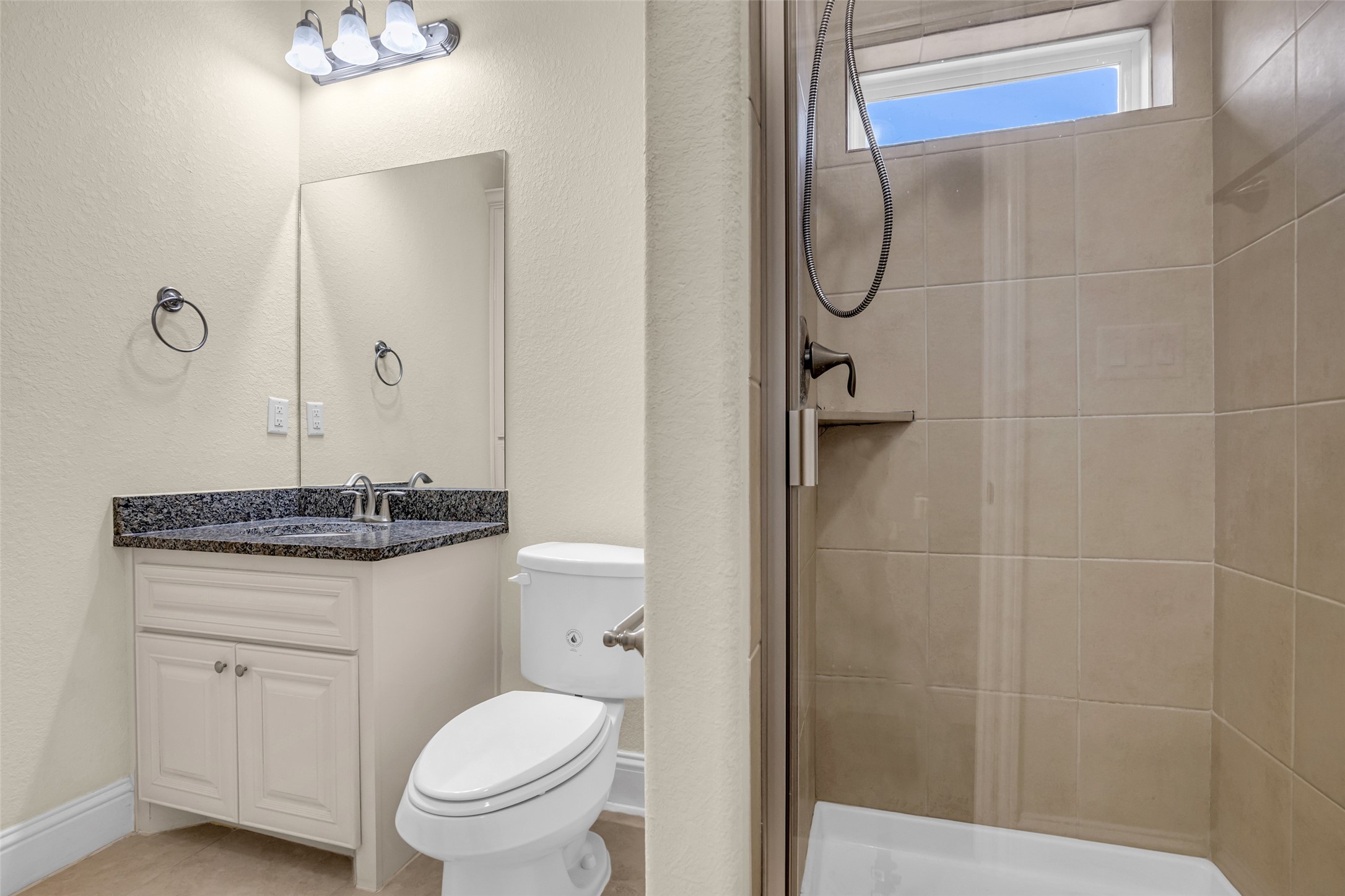 323 Texas Avenue Arcola, TX 77583 - Photo 22 of 27 a bathroom with a granite countertop toilet sink and shower
