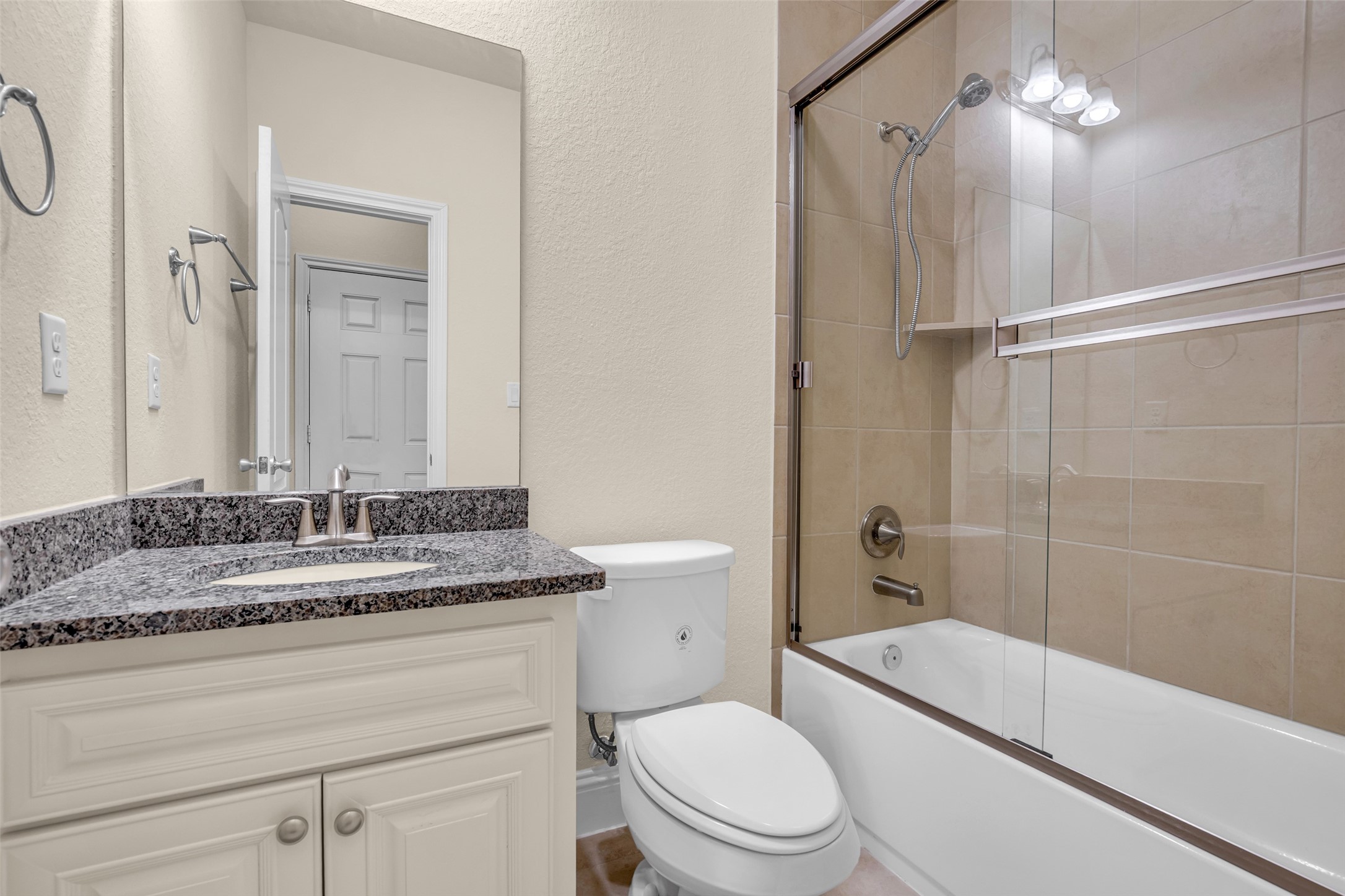 323 Texas Avenue Arcola, TX 77583 - Photo 24 of 27 a bathroom with a granite countertop sink a toilet and shower