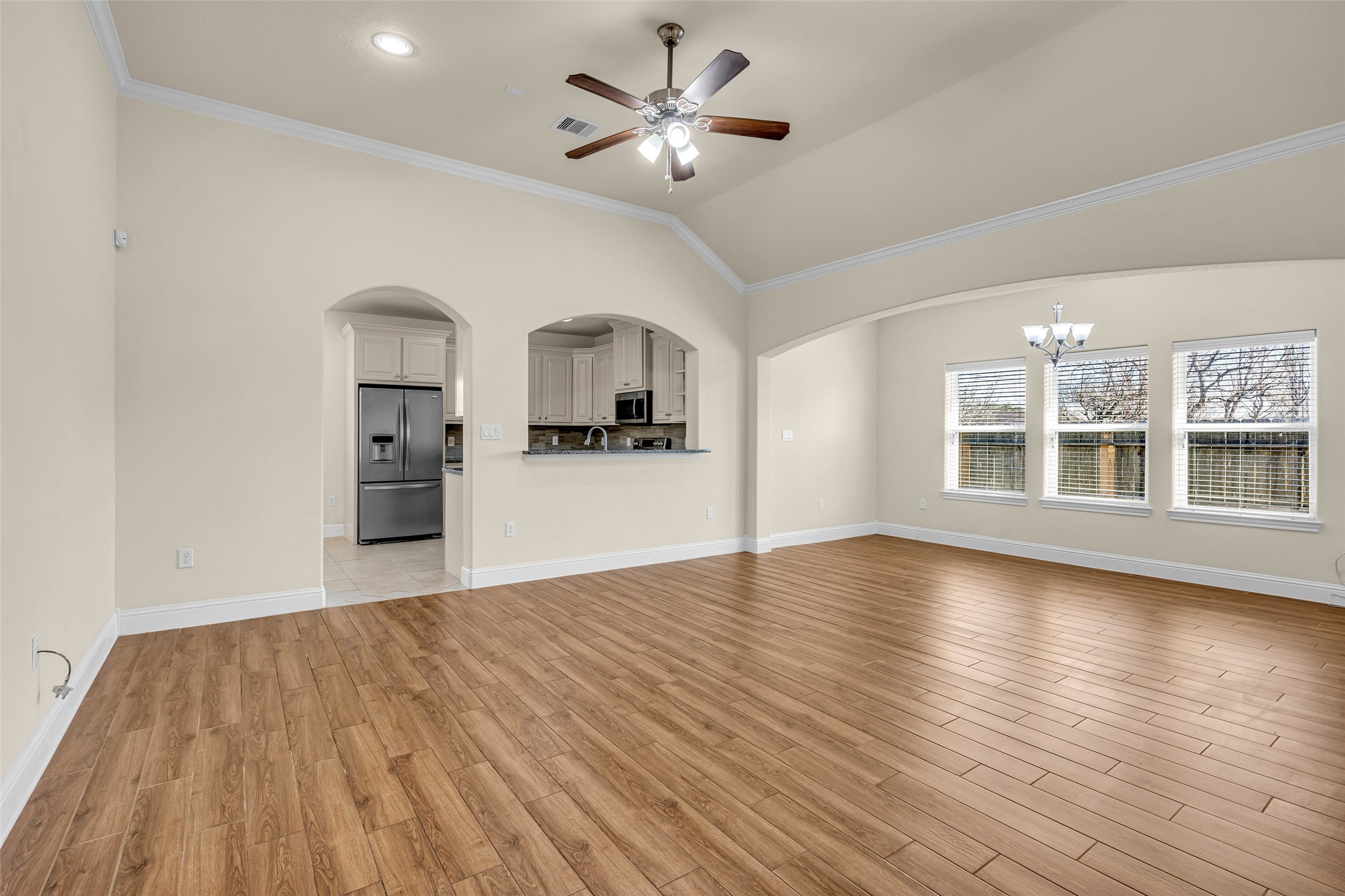 323 Texas Avenue Arcola, TX 77583 - Photo 5 of 27 a view of a kitchen with wooden floor and a ceiling fan