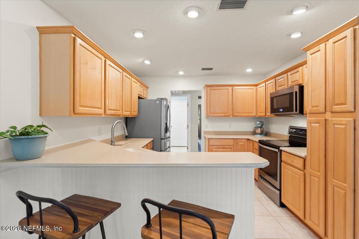 1489 Marshview Court Atlantic Beach, FL 32233 - Photo 13 of 47 a kitchen with stainless steel appliances granite countertop a sink a stove a refrigerator cabinets and chairs