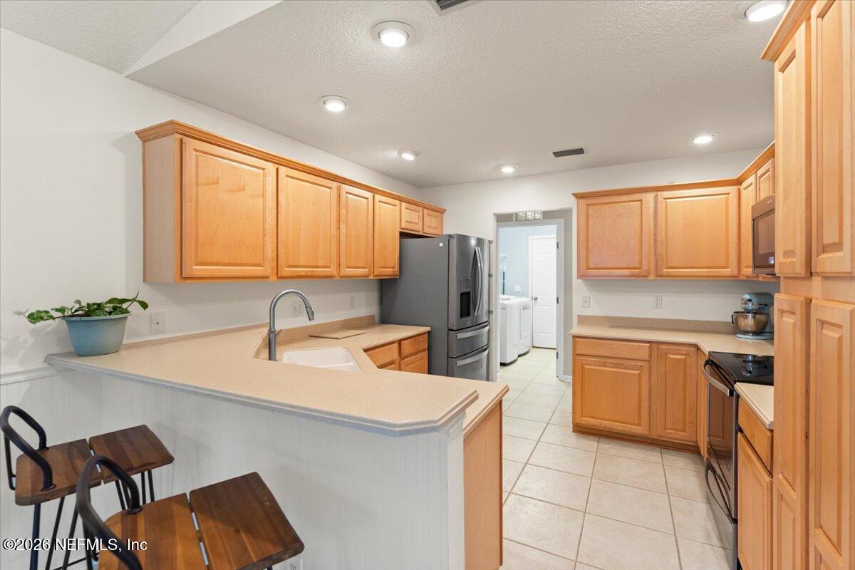 1489 Marshview Court Atlantic Beach, FL 32233 - Photo 14 of 47 a kitchen with stainless steel appliances granite countertop a sink refrigerator and cabinets