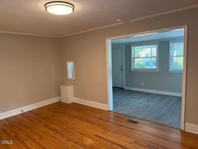 a view of empty room with wooden floor