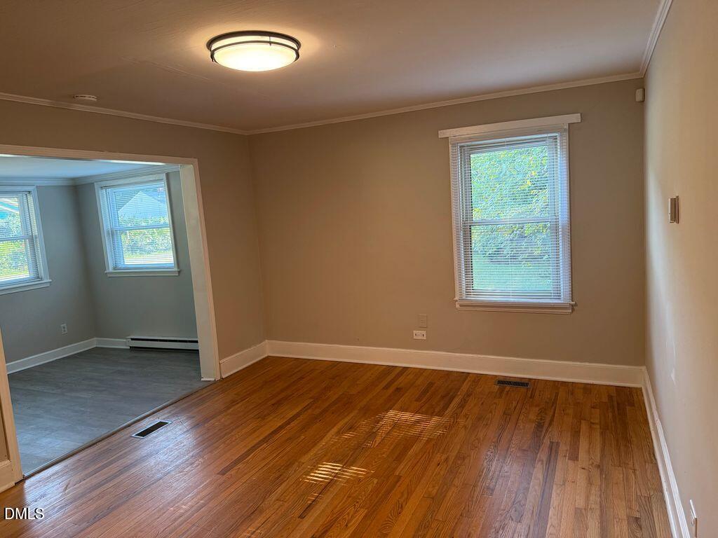 619 Old Oxford Road Durham, NC 27704 - Photo 5 of 22 an empty room with wooden floor and windows