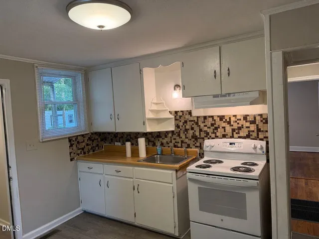 a kitchen with a stove a sink and a cabinet