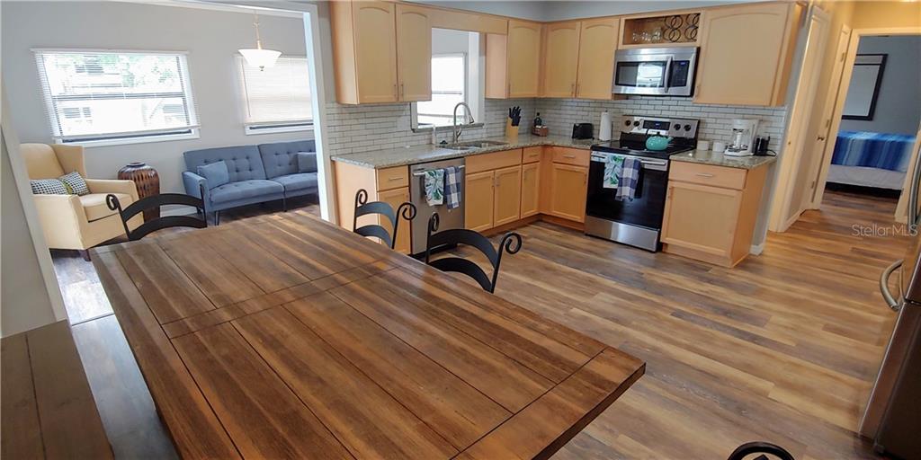 309 Shore T Road Nokomis, FL 34275 - Photo 12 of 42 a kitchen with a table chairs refrigerator and a window