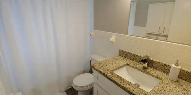 a bedroom with a bed and flat tv screen on the dresser