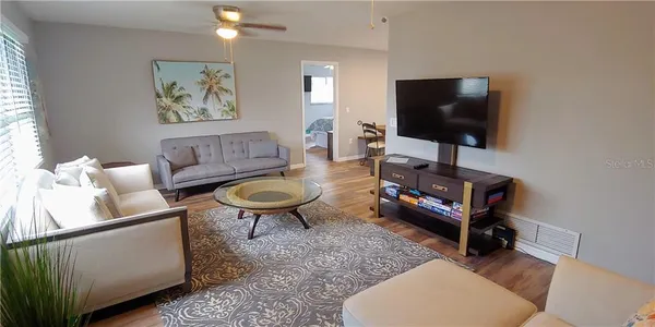 a living room with furniture and a wooden floor