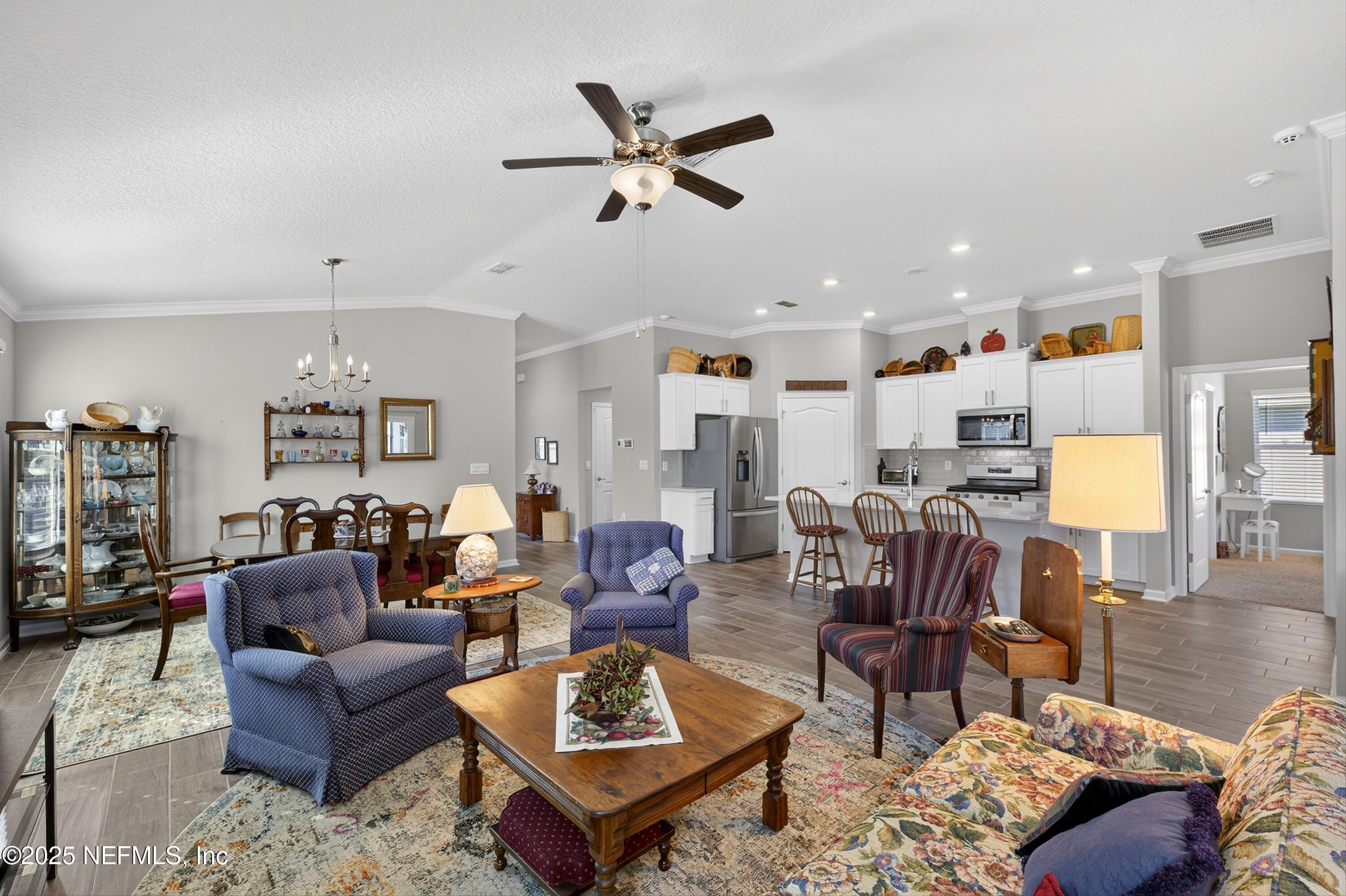 70 Spoonbill Circle St. Augustine, FL 32095 - Photo 16 of 76 a living room with furniture kitchen view and a chandelier