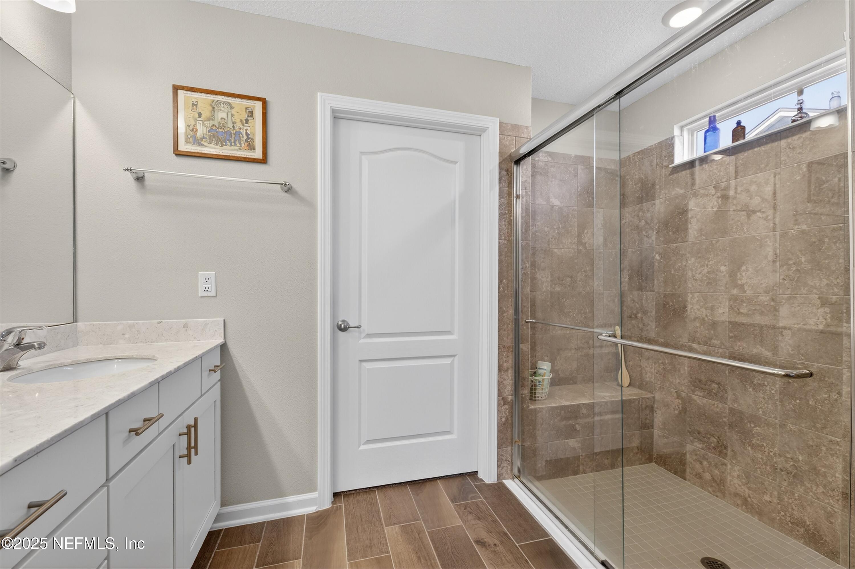 70 Spoonbill Circle St. Augustine, FL 32095 - Photo 23 of 76 a bathroom with a granite countertop sink a mirror a shower and a bathtub