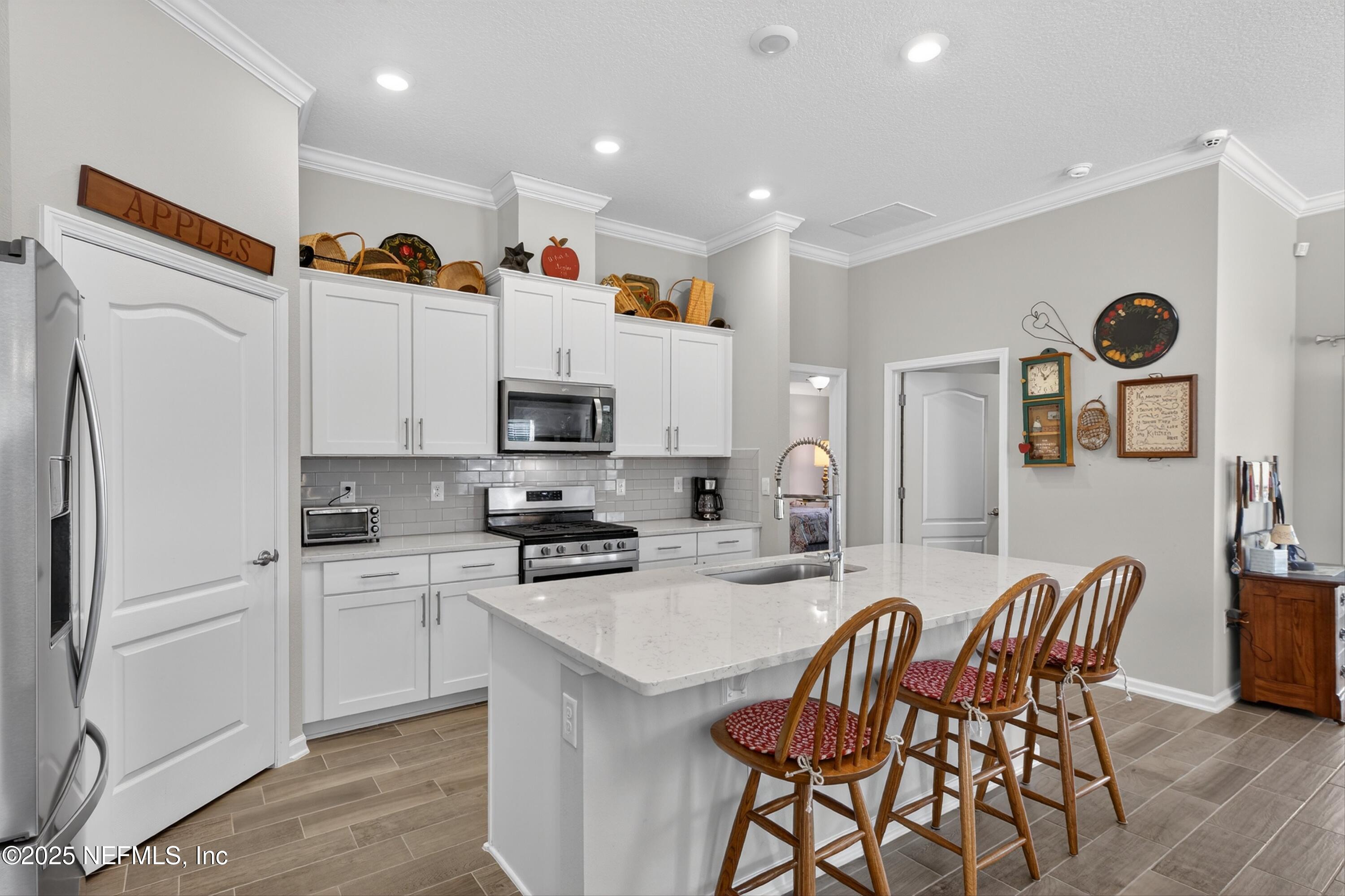 70 Spoonbill Circle St. Augustine, FL 32095 - Photo 8 of 76 a kitchen with stainless steel appliances a refrigerator a stove a sink a dining table and chairs with wooden floor