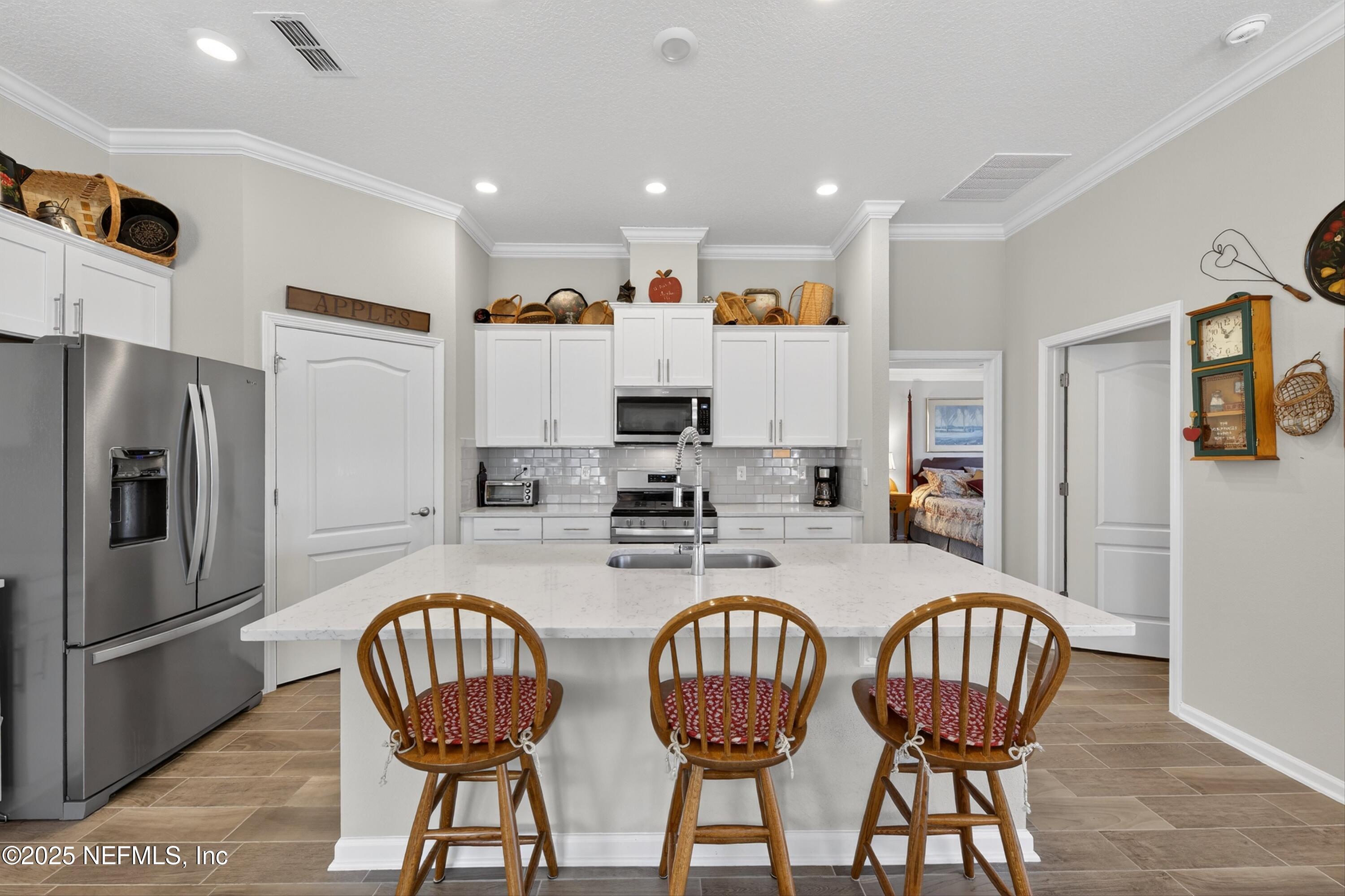 70 Spoonbill Circle St. Augustine, FL 32095 - Photo 9 of 76 a kitchen with stainless steel appliances granite countertop a dining table chairs refrigerator and microwave