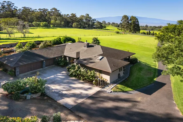 an aerial view of a house with a yard and lake view