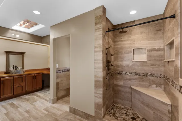 a bathroom with a glass door shower a sink and a mirror