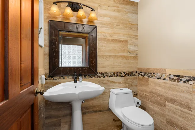 a bathroom with a sink a toilet and mirror