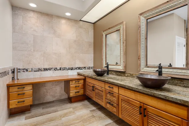 a spacious bathroom with double vanity and a large mirror