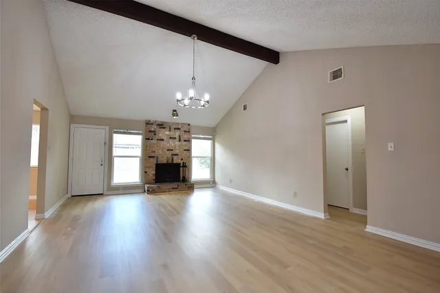 a view of a livingroom with a fireplace wooden floor and window