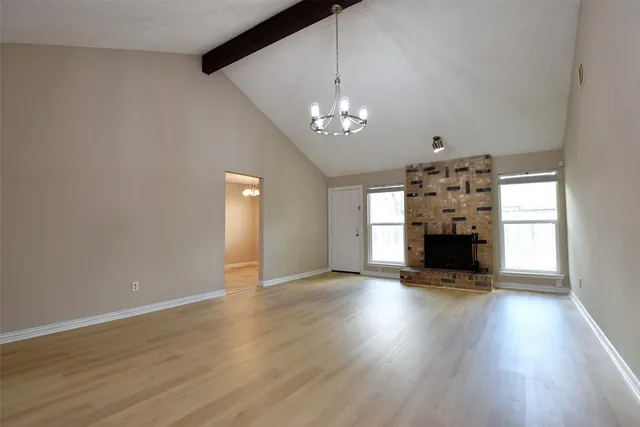 a view of empty room with wooden floor and fireplace