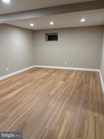 an empty room with wooden floor and entrance