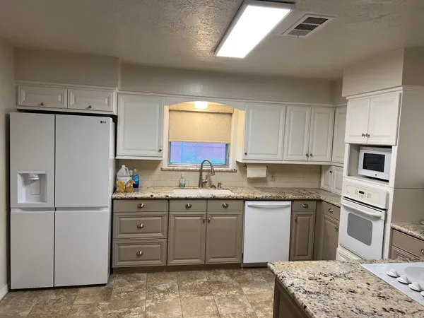 a kitchen with a refrigerator sink and cabinets