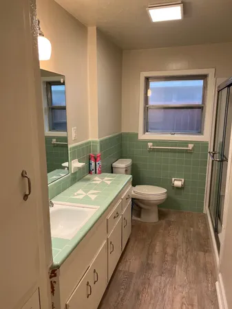 a bathroom with a sink a toilet and a mirror