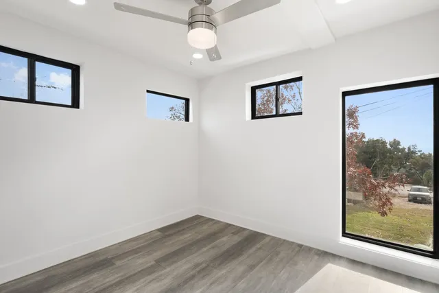 a view of a big room with wooden floor and windows