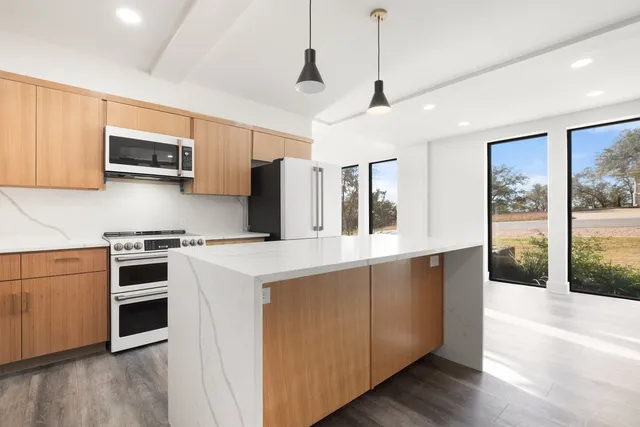 a kitchen with stainless steel appliances granite countertop a stove a sink and a refrigerator