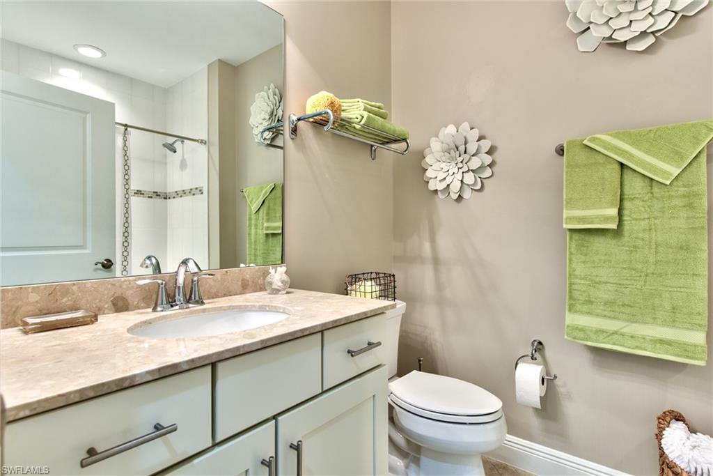 10470 Casella Way, Unit 101 Fort Myers, FL 33913 - Photo 18 of 34 a bathroom with a granite countertop sink a toilet and a mirror