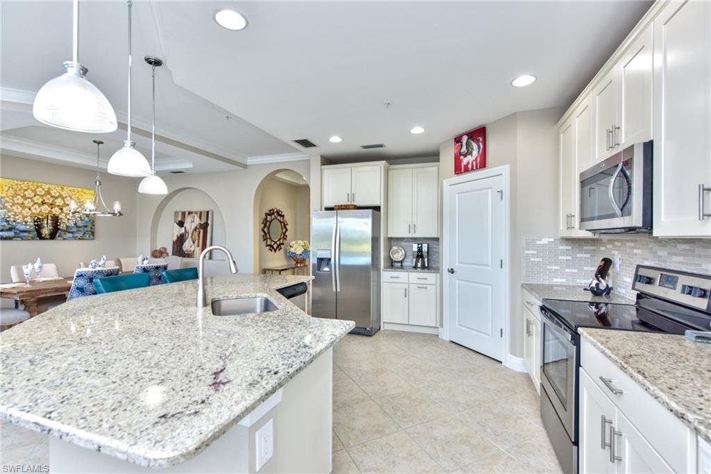 10470 Casella Way, Unit 101 Fort Myers, FL 33913 - Photo 5 of 34 a kitchen with stainless steel appliances granite countertop a sink a stove and a refrigerator