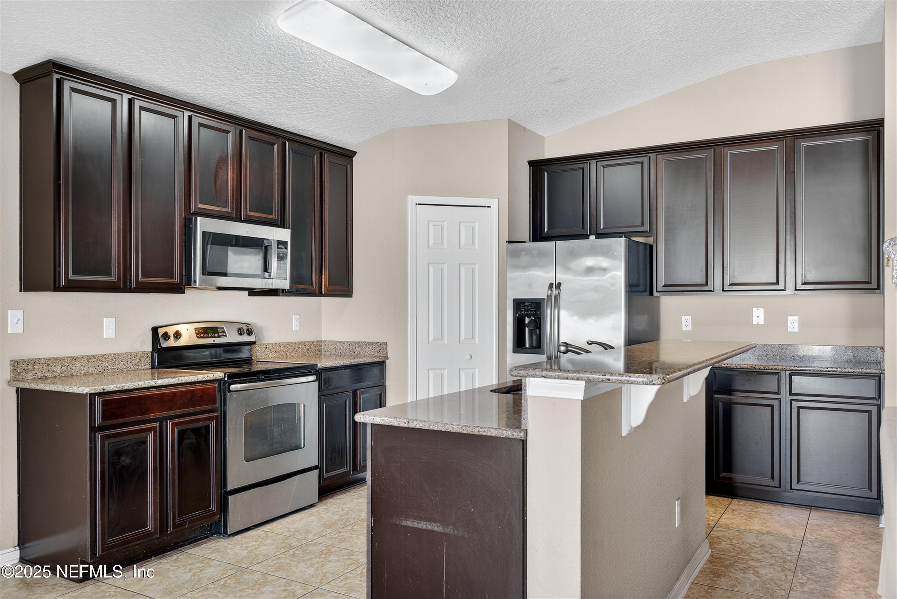 4045 Trail Ridge Road Middleburg, FL 32068 - Photo 16 of 45 a kitchen with stainless steel appliances granite countertop a stove top oven a sink and dishwasher