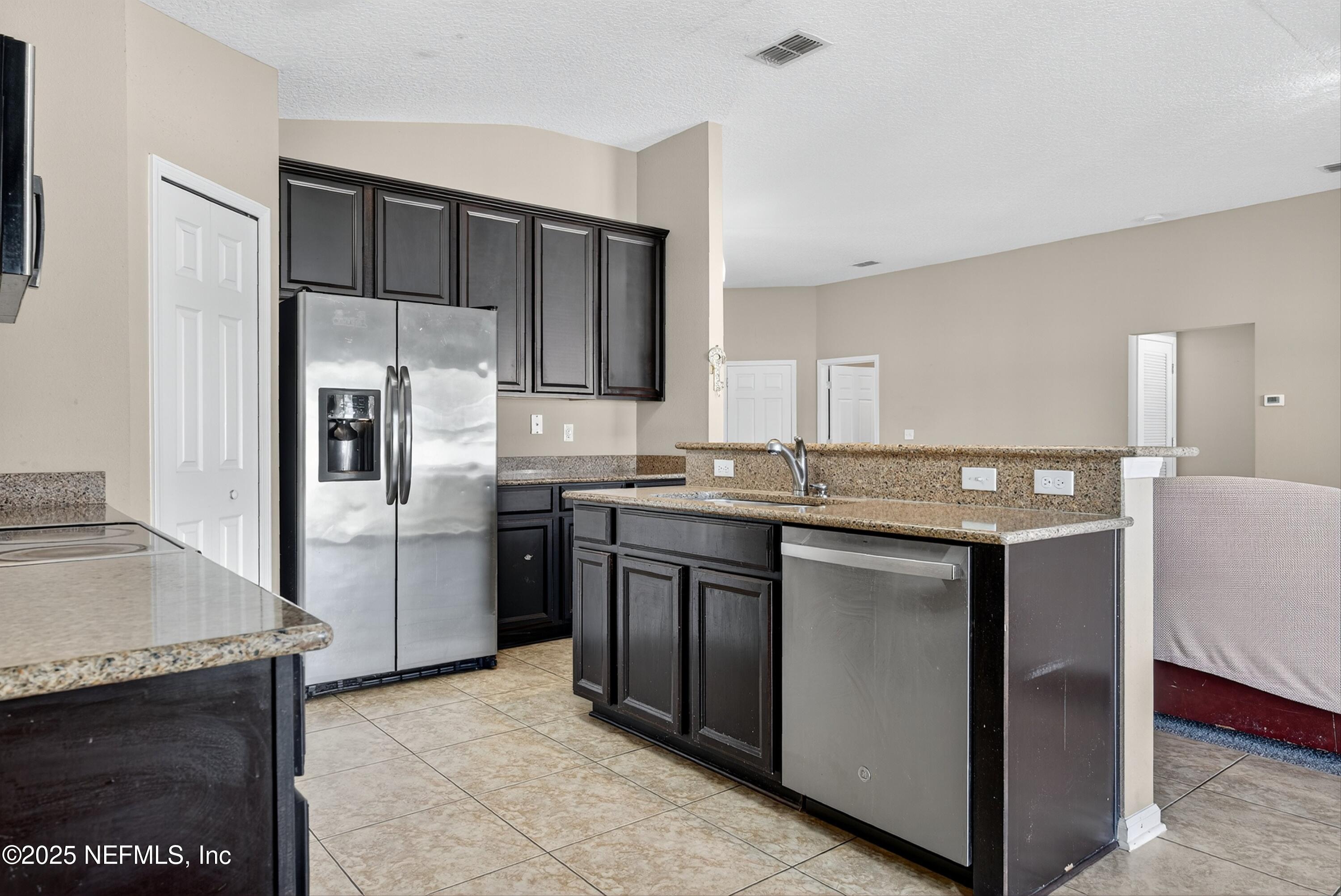 4045 Trail Ridge Road Middleburg, FL 32068 - Photo 17 of 45 a kitchen with stainless steel appliances granite countertop a refrigerator and a sink
