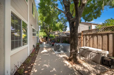 a view of a patio with table and chairs with wooden floor and fence