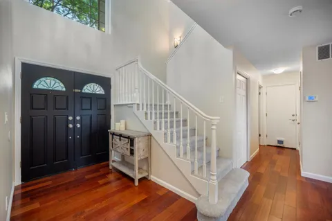 a view of a hallway with entryway wooden floor and front door