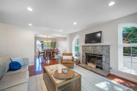 a living room with furniture a fireplace and a flat screen tv