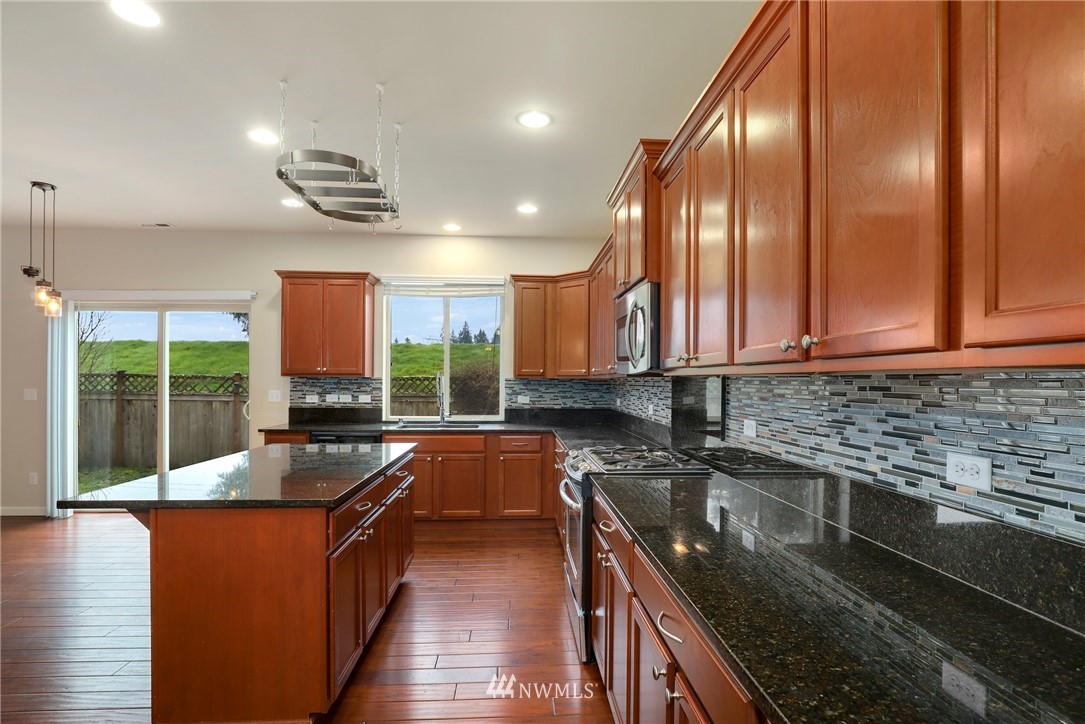 7301 Radius Loop Southeast Lacey, WA 98513 - Photo 12 of 39 a kitchen with stainless steel appliances granite countertop a sink a stove counter space and a window